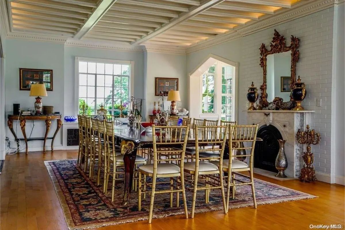 Large dining area with gold-framed chairs surrounding a polished wooden table.