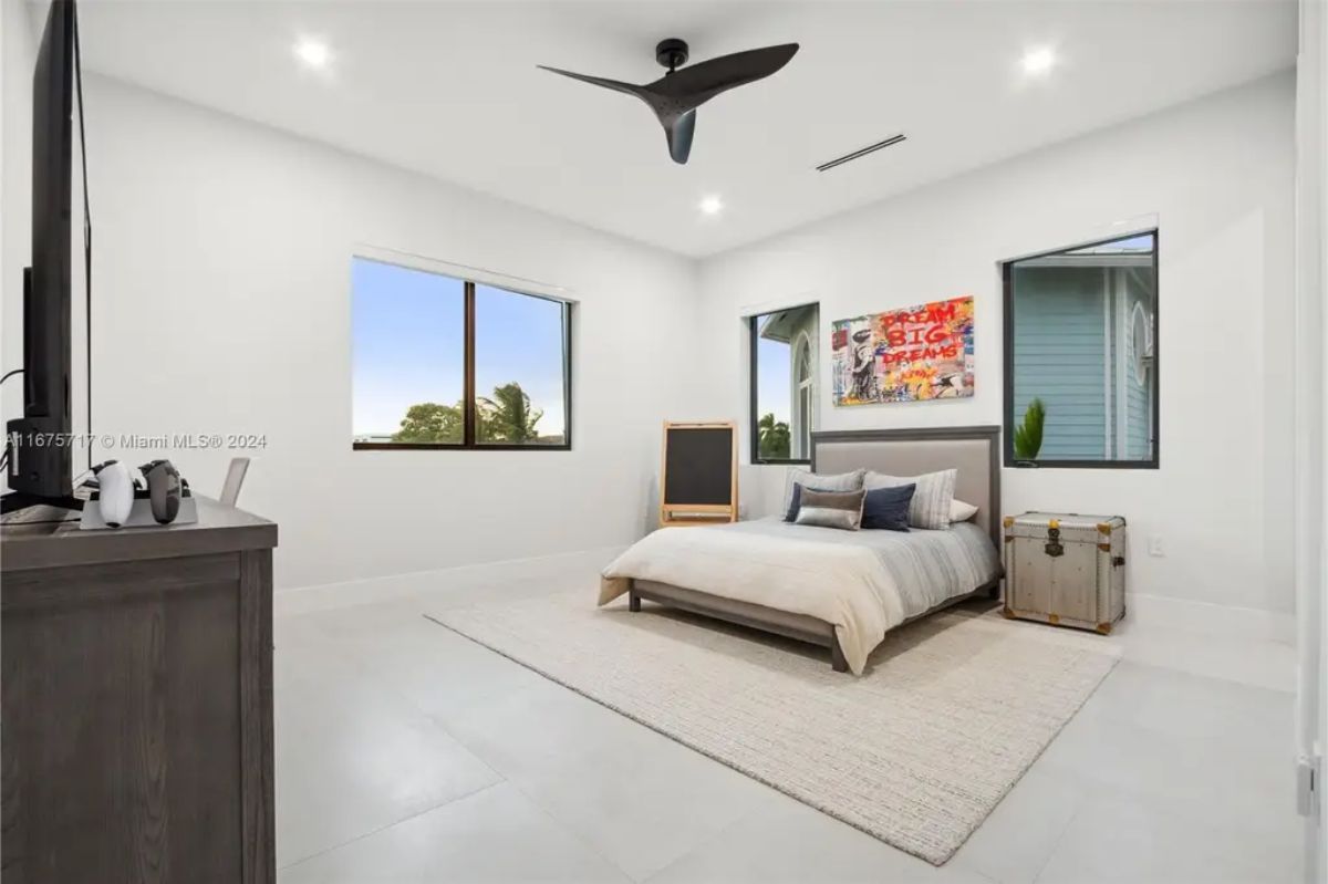 Minimalist bedroom with neutral decor, a large bed, and modern artwork on the wall. 