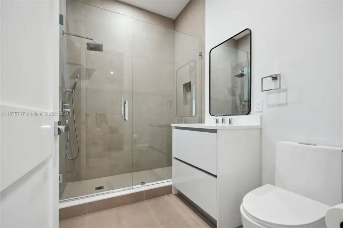 Sleek bathroom with a glass-enclosed shower, floating vanity, and contemporary fixtures. 