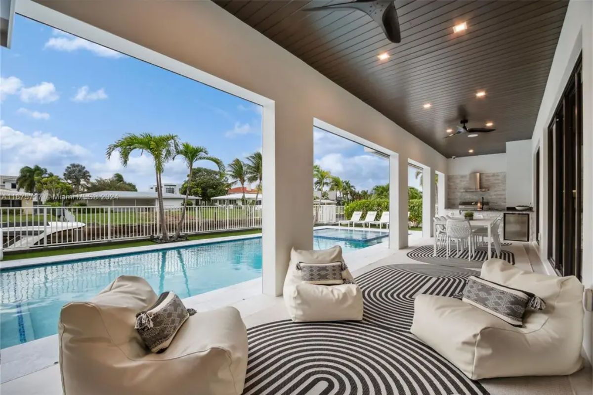 Stunning outdoor patio with comfortable seating, an outdoor kitchen, and a poolside view. 