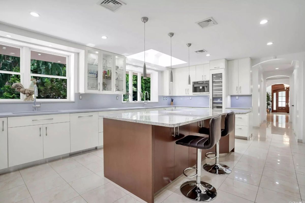 Spacious kitchen with white cabinetry and stainless steel appliances.