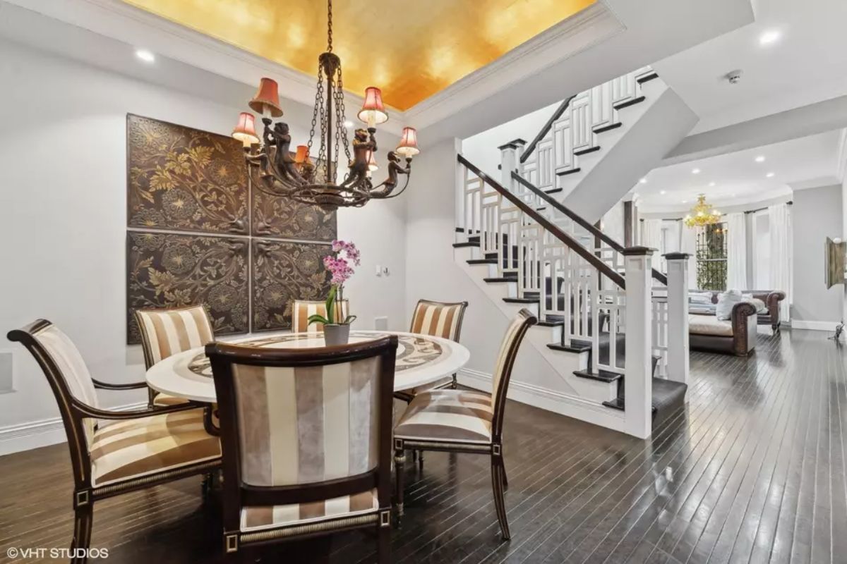Dark hardwood flooring contrasts with white walls and a gold-accented ceiling.