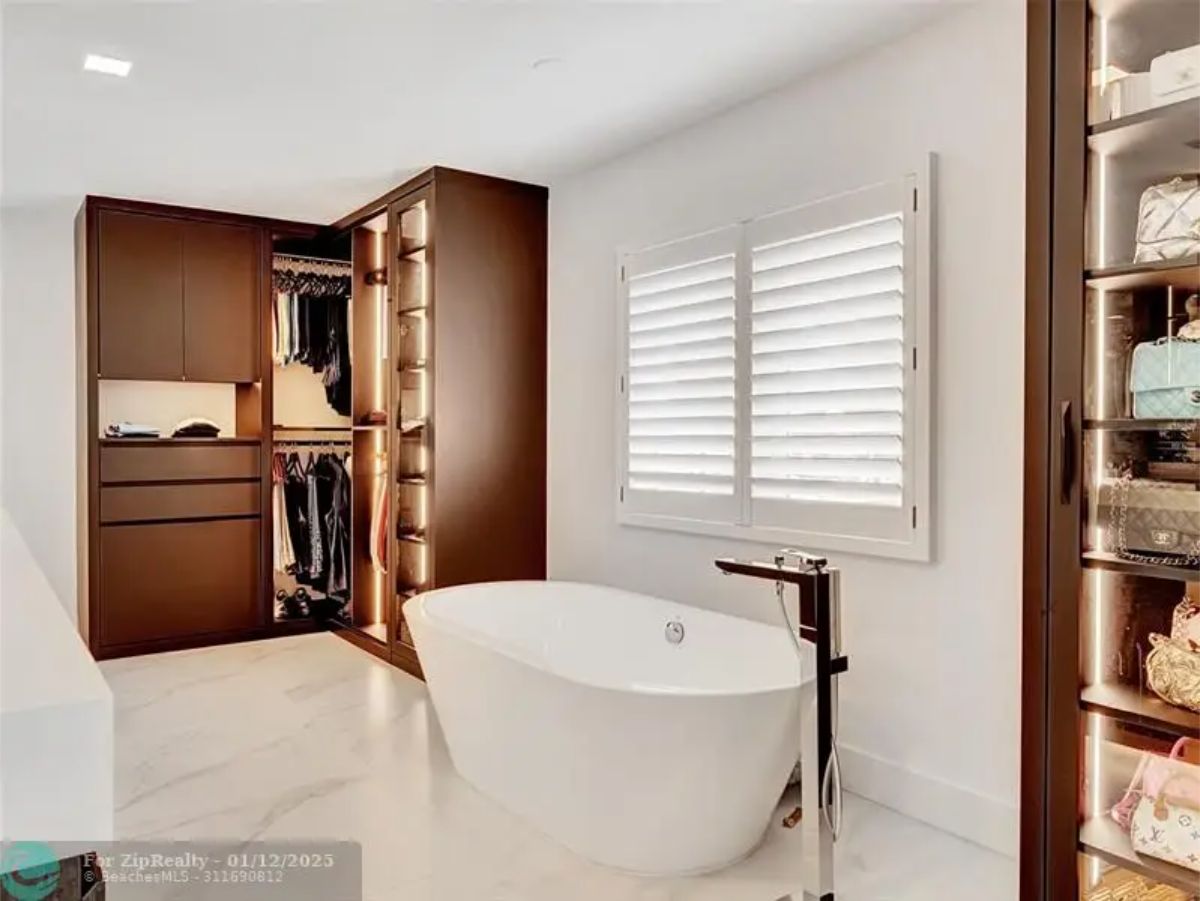 Elegant bathroom with a soaking tub, built-in wardrobe, and warm lighting for a cozy atmosphere. 