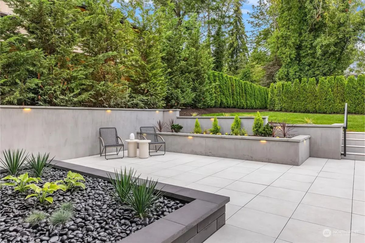Tranquil outdoor patio with lush greenery, minimalist design, and comfortable seating. 