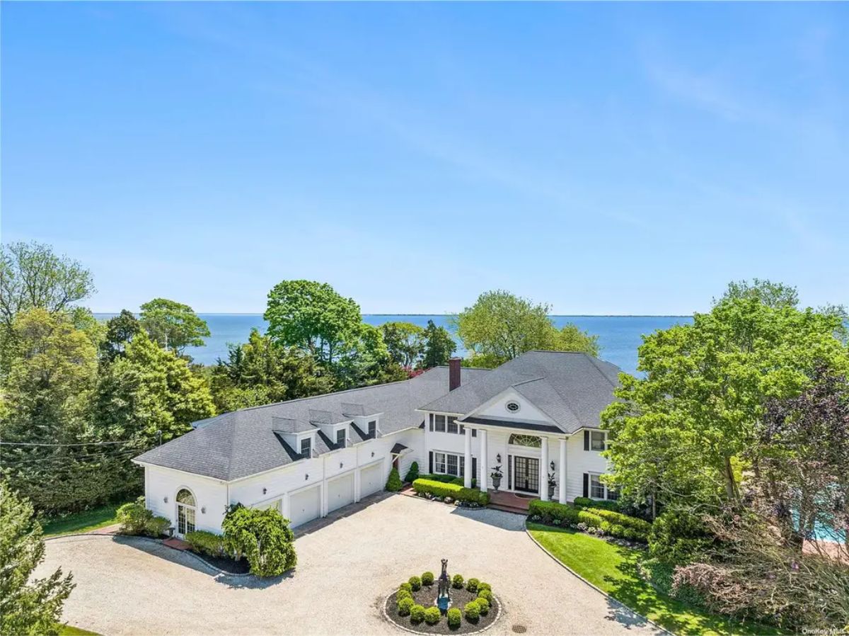 This $7,250,000 waterfront estate in Bellport spans 7,200 sq. ft. with 5 bedrooms and 8 bathrooms on 2.5 acres. Built in 1915, the home features a study, lounge with bar, oversized kitchen, and multiple recreation areas.