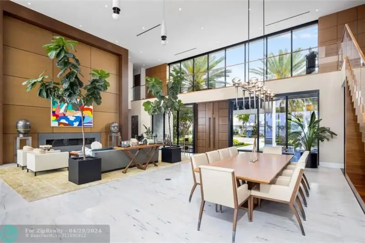 Spacious living and dining area with high ceilings, large windows, and modern furniture. 