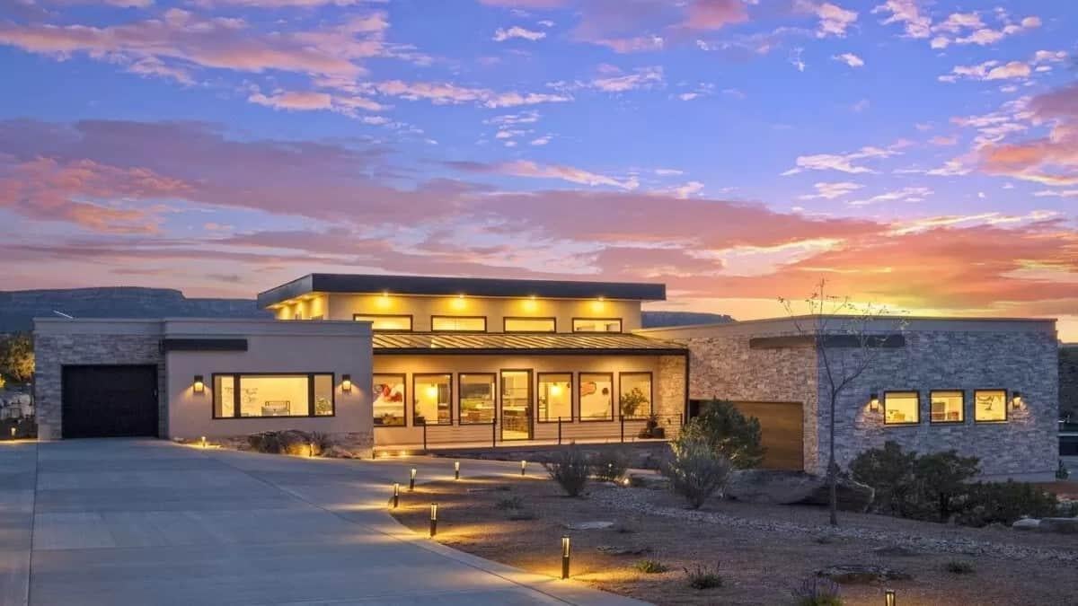 Modern Home with Striking Roofline and Stone Accents at Sunset