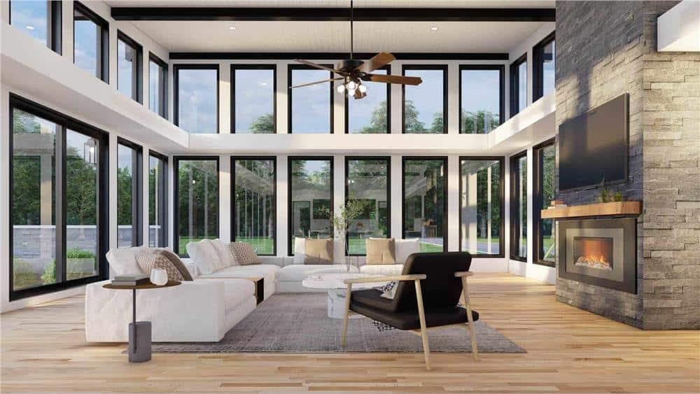 Marvel at This Light-Filled Living Room with Expansive Windows and Stone Fireplace