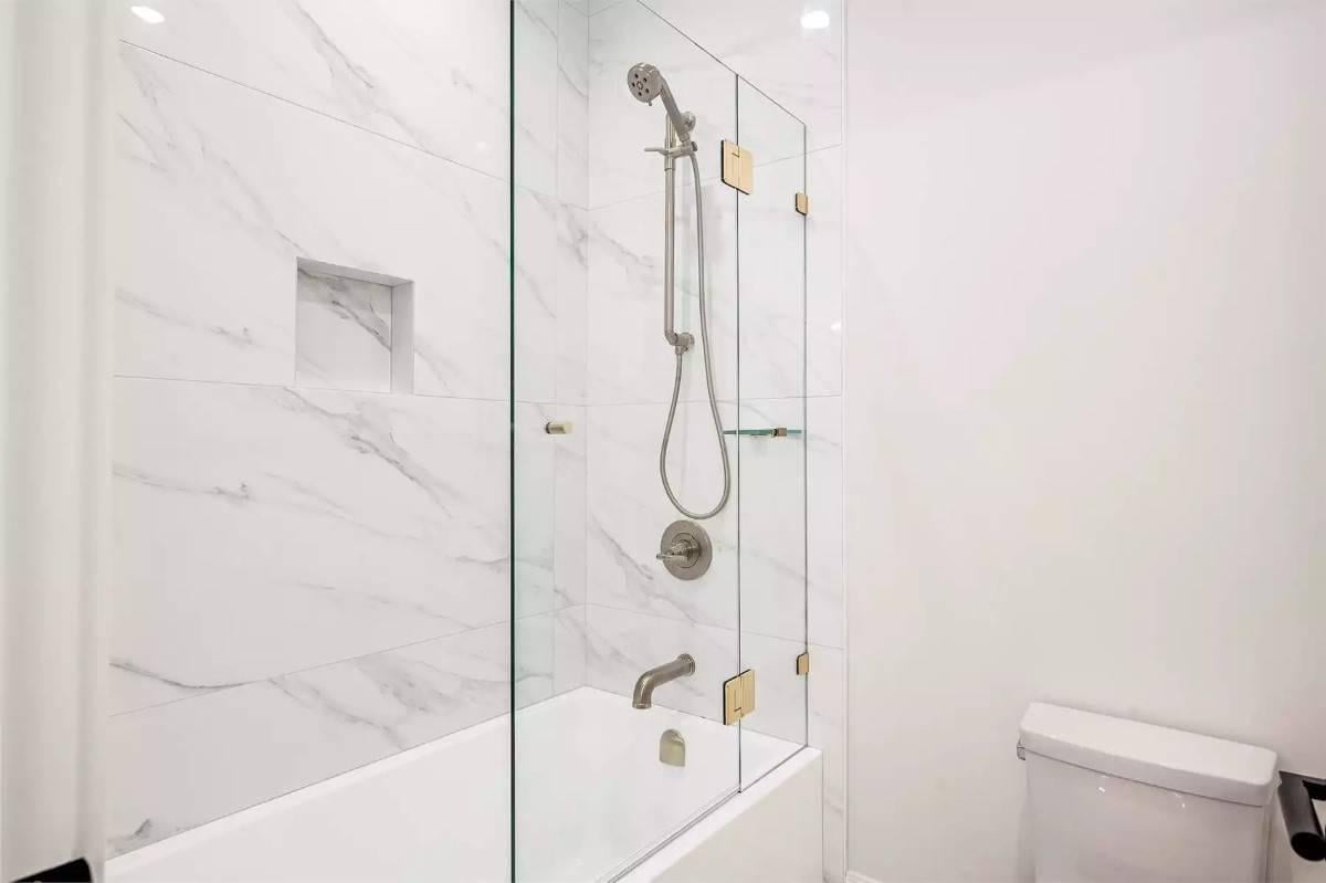 Look at the Elegant Marble Tile and Glass Enclosure in This Minimalist Bathroom
