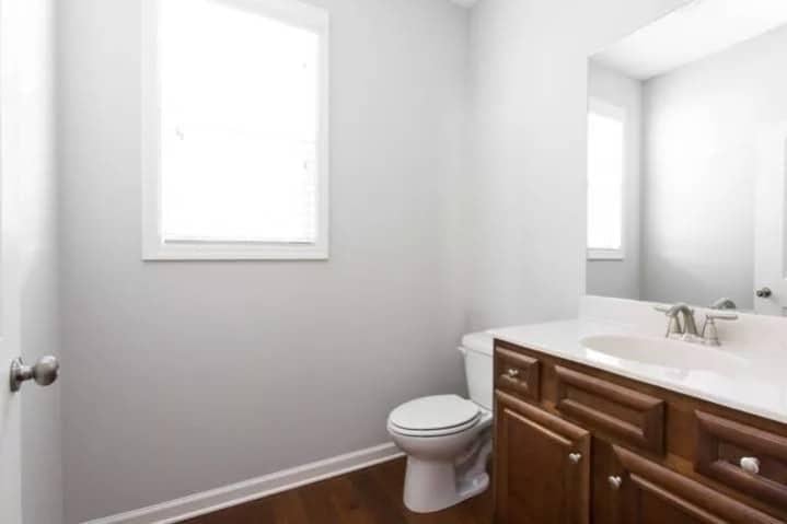 Simple Powder Room Featuring Classic Wooden Vanity