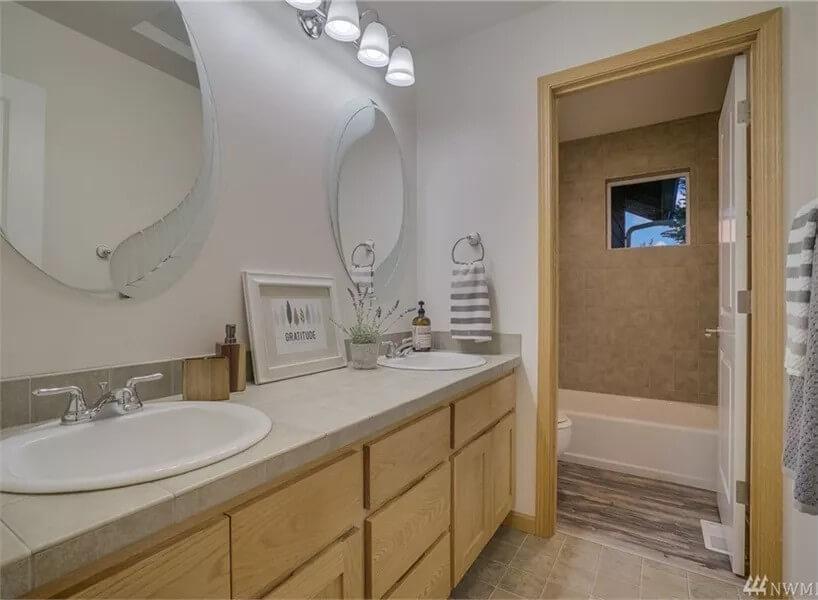 Charming Bathroom Design with Dual Ovals and a Handsome Vanity