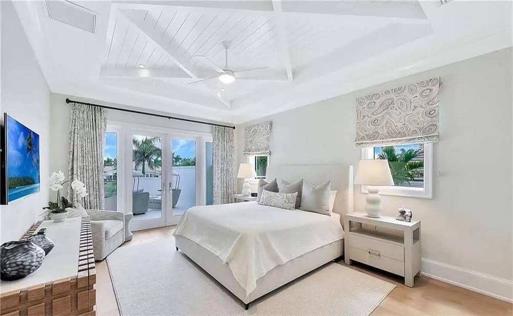 Check Out the Vaulted Ceiling and Balcony Access in This Bright Bedroom