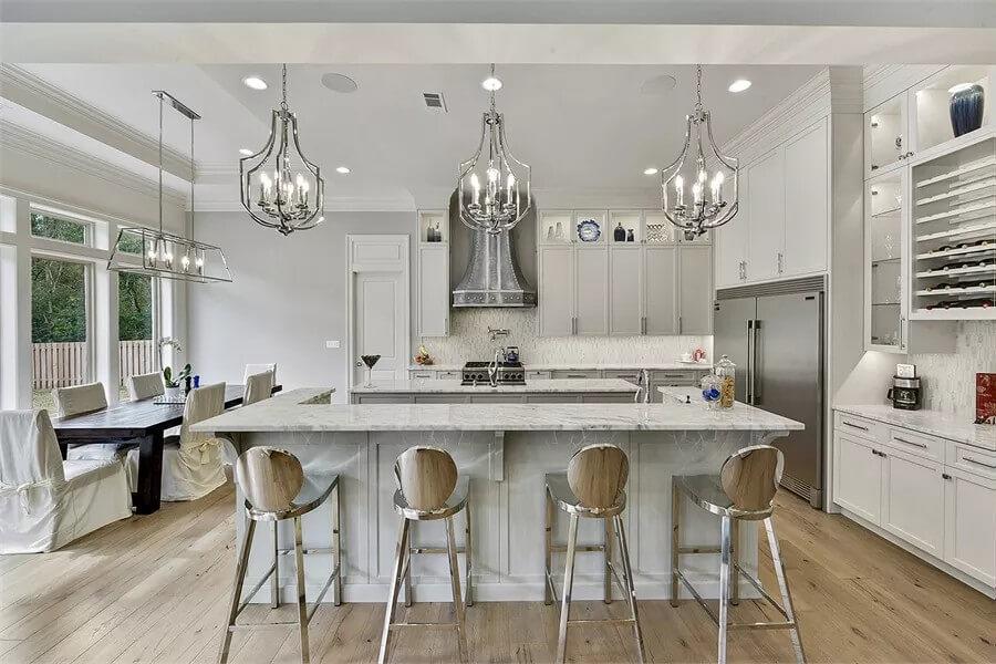 Notice the Ornate Chandeliers Paired with a Marble Island