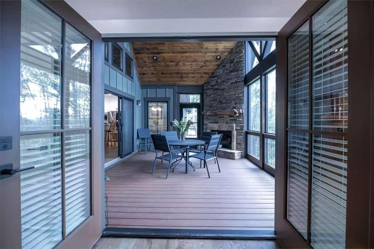 Step Into This Screened Porch with Its Rustic Timber Ceiling