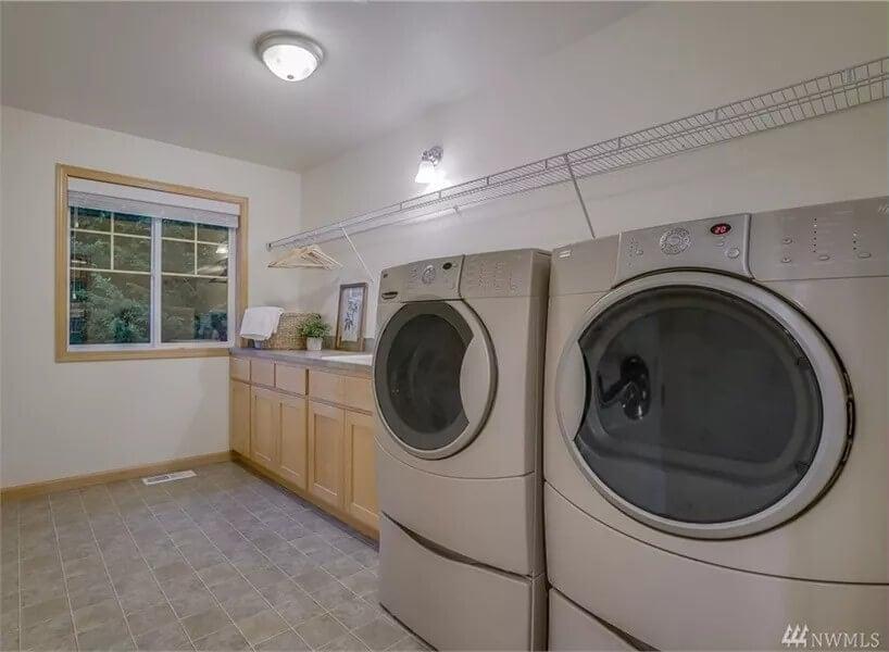 Spacious Laundry Room with Sleek Appliances and Practical Storage