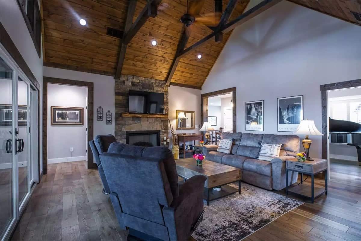 Vaulted Living Room with Timber Ceiling and Stone Fireplace