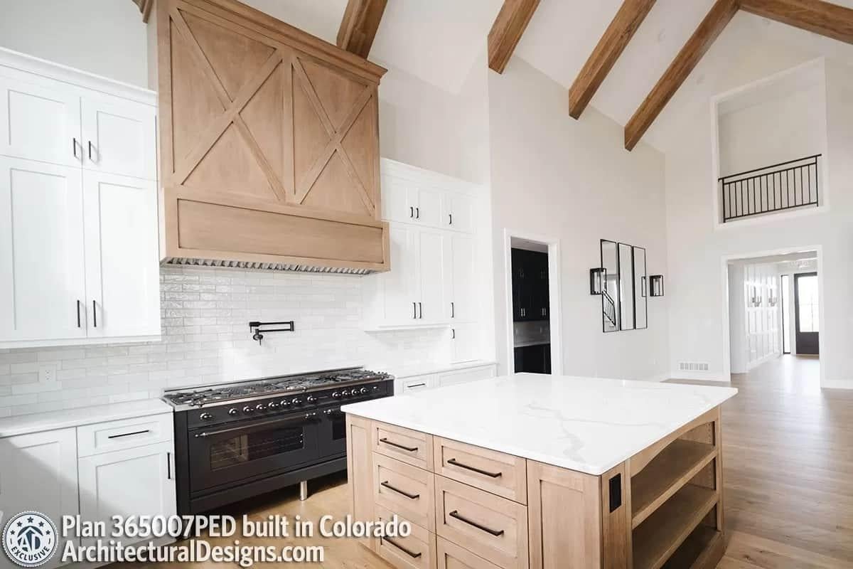 Gorgeous Wood Detailing with a Dramatic Range Hood in This Kitchen