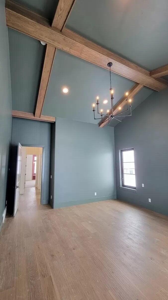 Vaulted Ceiling with Natural Wood Beams Adds Character to This Minimalist Room