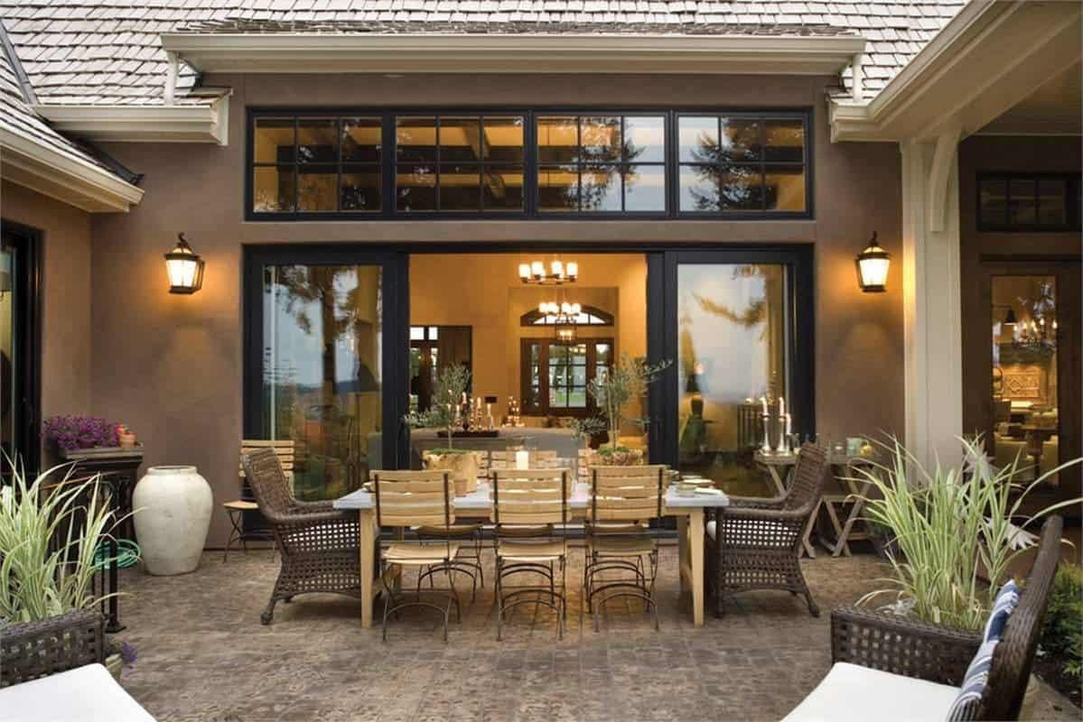 Elegant Outdoor Dining Area with Warm Lighting and Classic French Doors
