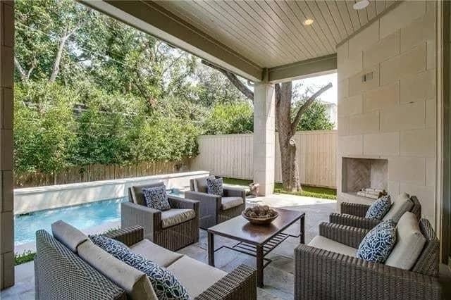 Covered Patio With Pool Views and a Stone Fireplace