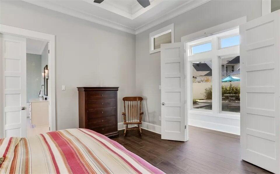 Admire the Tray Ceiling and Versatile Double Doors in This Bedroom