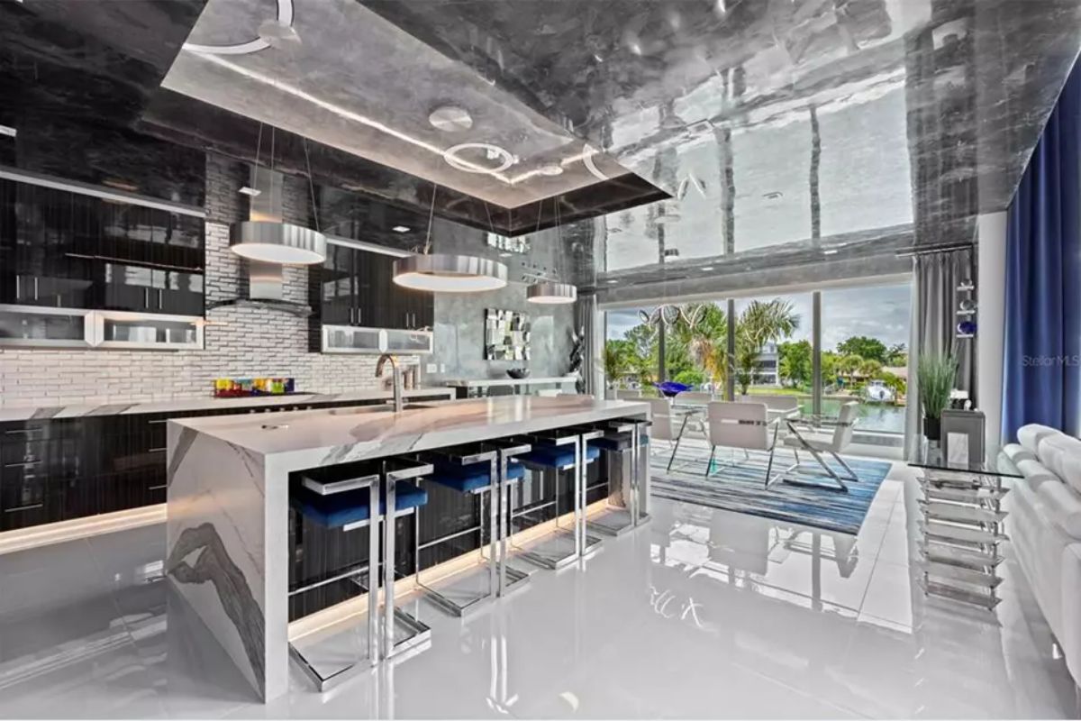 Kitchen includes waterfall island with integrated cooktop and bar seating.