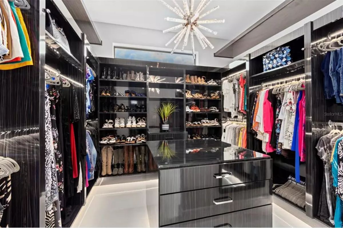 Closet includes black cabinetry, LED-lit shelves, and hanging rods.
