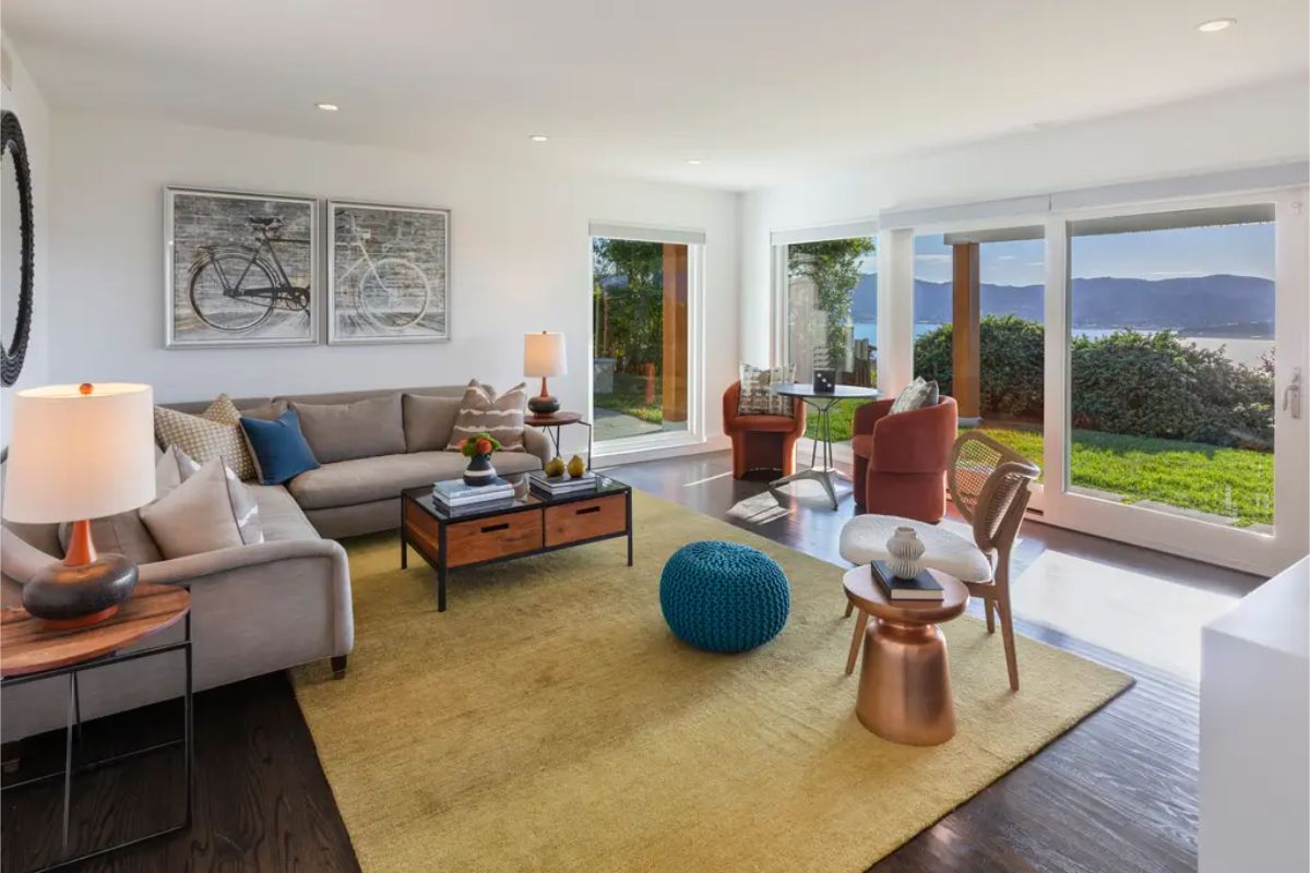 Cozy living room with a warm color palette, comfortable seating, and large sliding doors leading to an outdoor patio. 