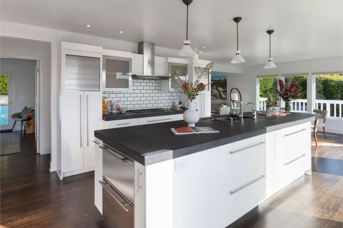 Stylish kitchen with a large center island, stainless steel appliances, and a crisp white aesthetic. 