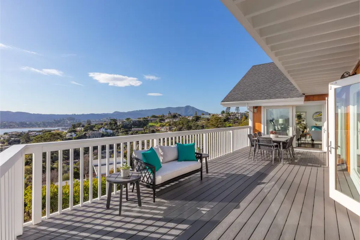 Expansive deck with outdoor seating, offering breathtaking panoramic views of the surrounding mountains and water. 