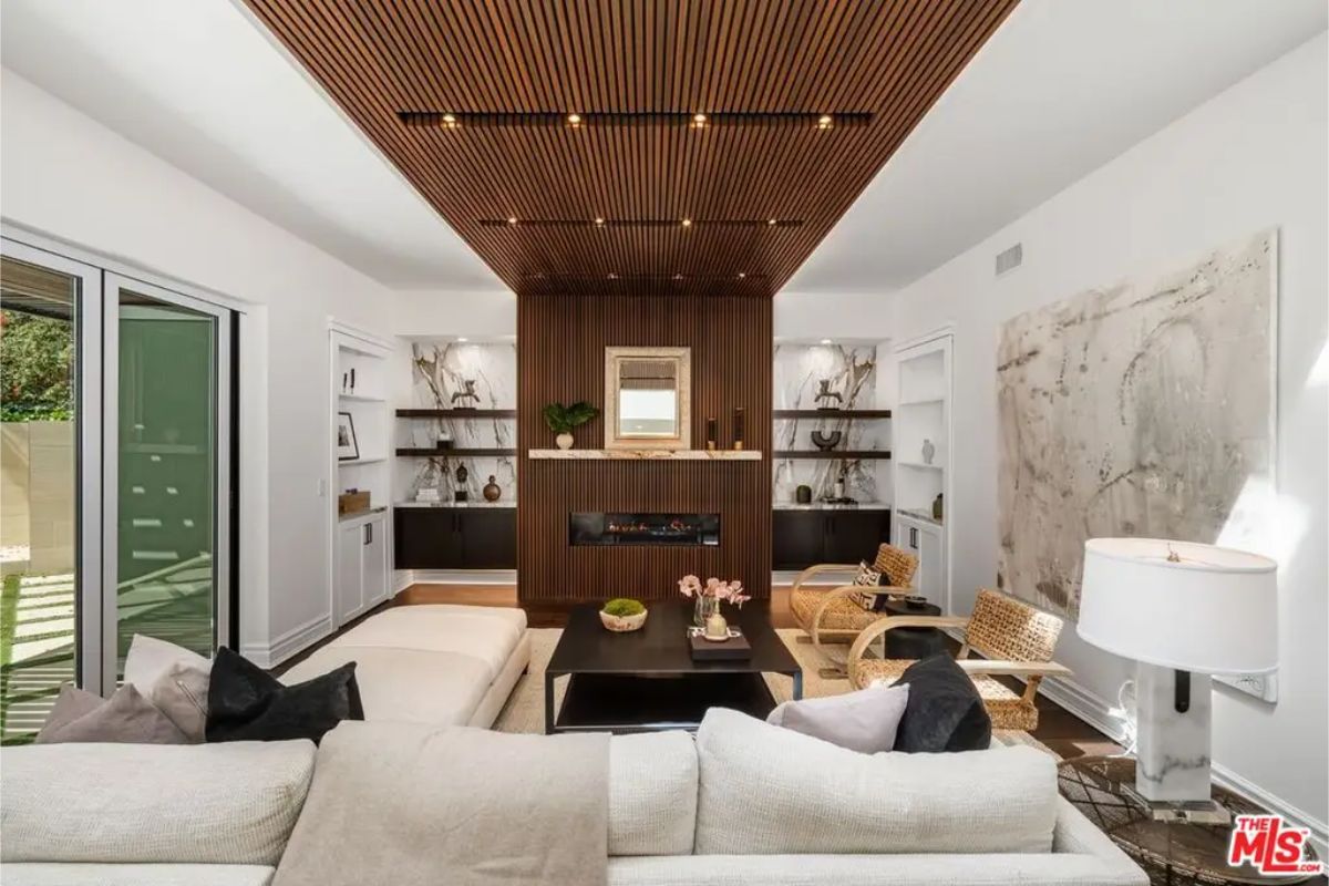 Cozy yet sophisticated sitting area with a built-in fireplace, wood paneling, and modern accents. 