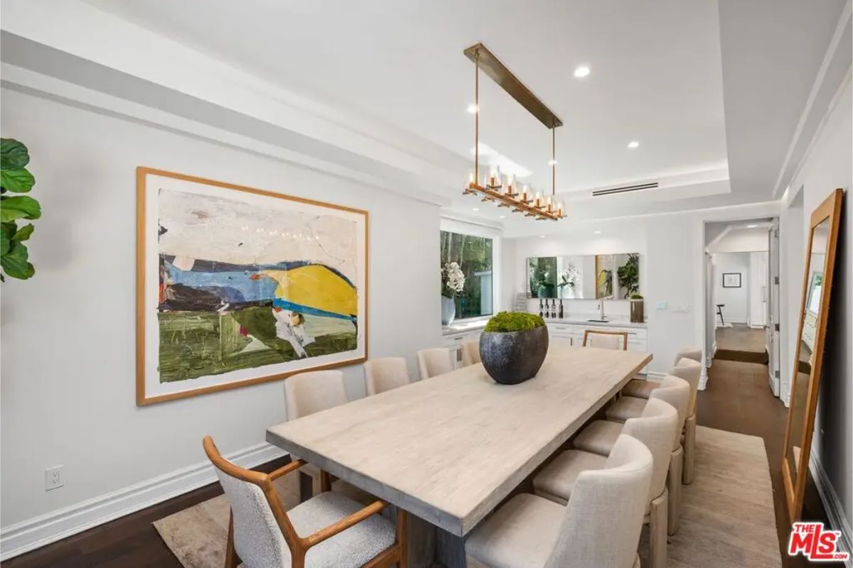 Elegant formal dining room with a marble table, plush chairs, and a striking chandelier. 