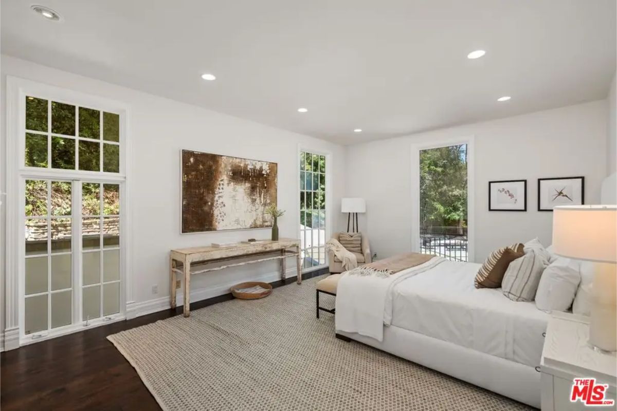 Bright and spacious bedroom with large windows, neutral tones, and a cozy minimalist design. 