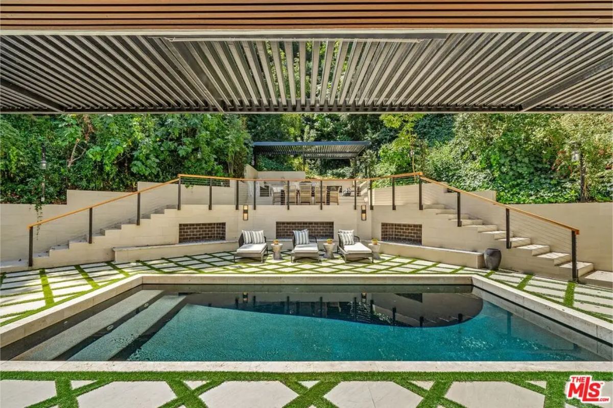 Beautiful poolside lounge area with tiered seating, greenery, and a tranquil atmosphere. 