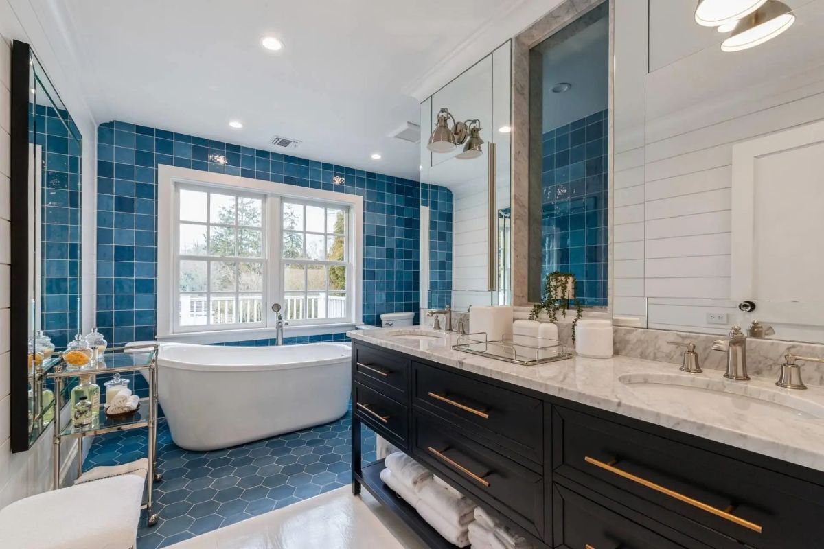 Deep blue tile covers the shower wall and extends behind the soaking tub.