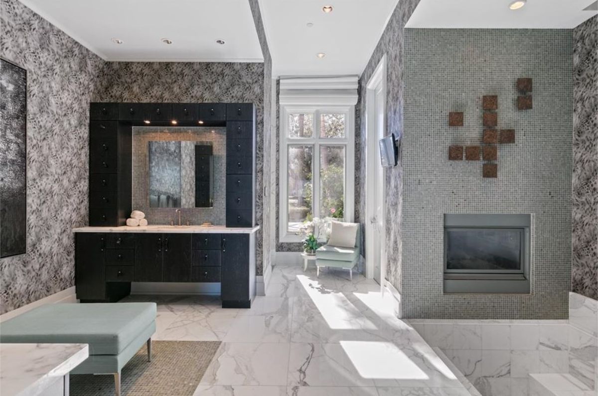 Elegant bathroom featuring a fireplace, marble flooring, and patterned wallpaper for a luxurious feel. 