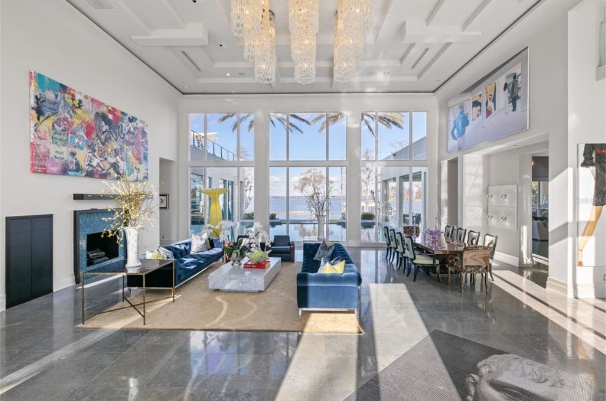 Spacious open-concept living and dining area with floor-to-ceiling windows offering a view of the outdoors. 