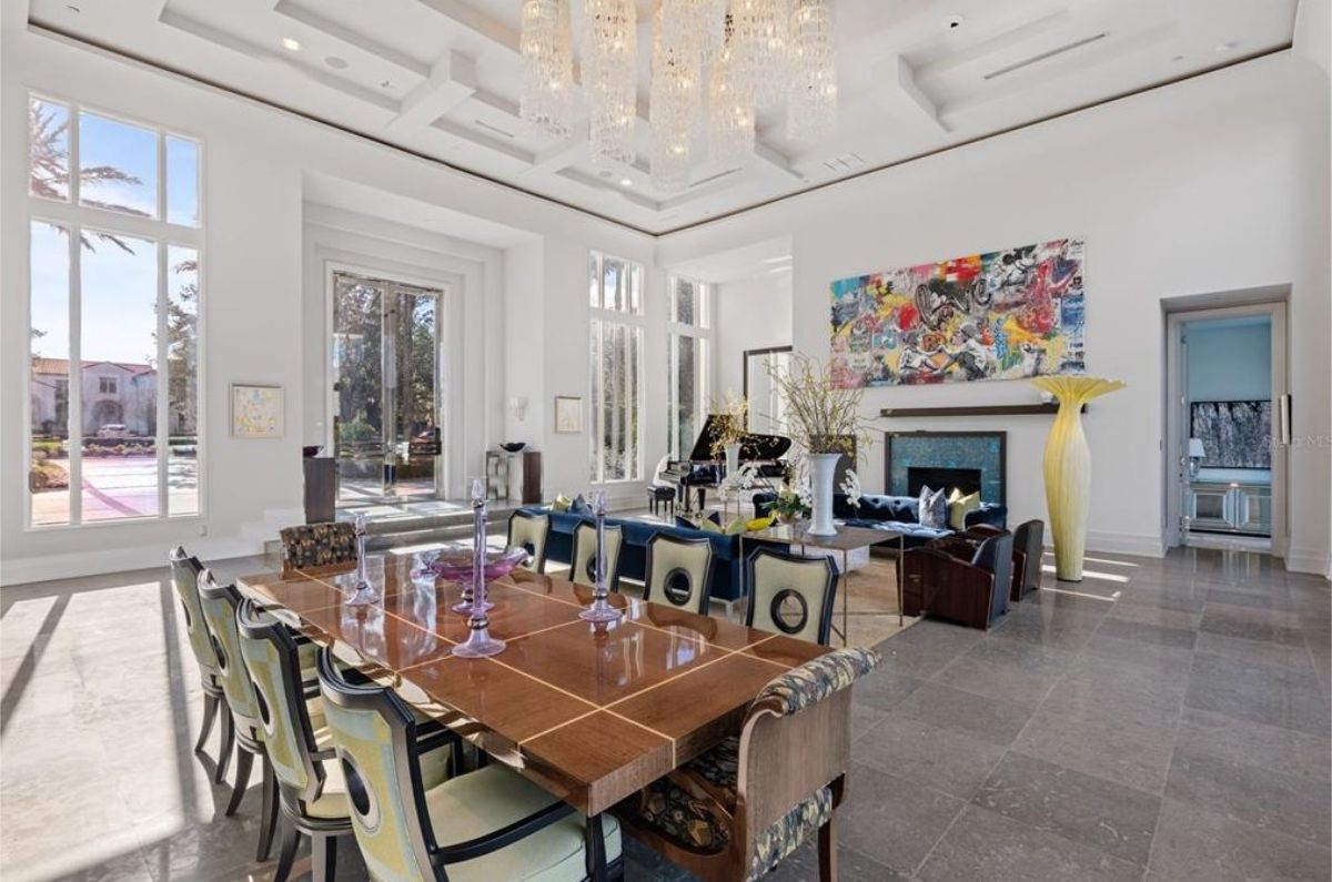 Sophisticated dining area with a long wooden table, unique chairs, and a contemporary chandelier. 
