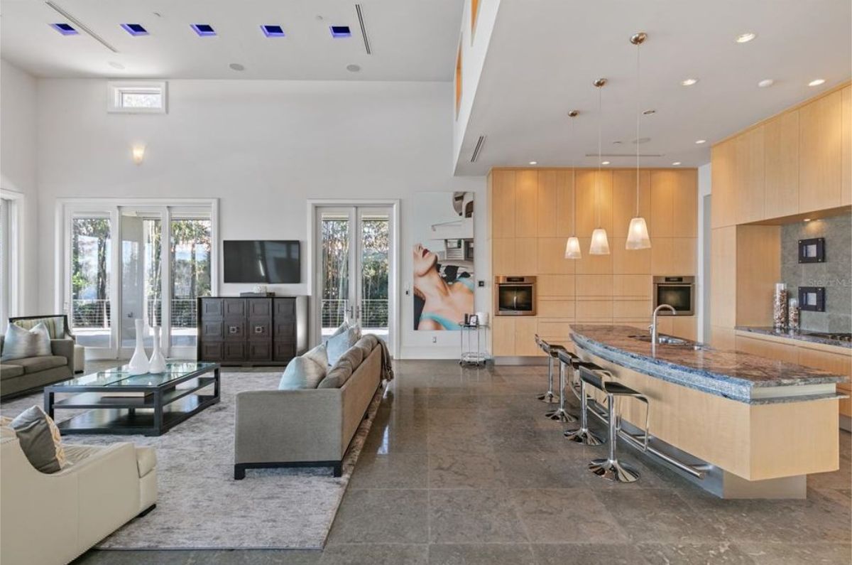 Stylish open-concept kitchen and lounge area with modern appliances and sleek furnishings. 