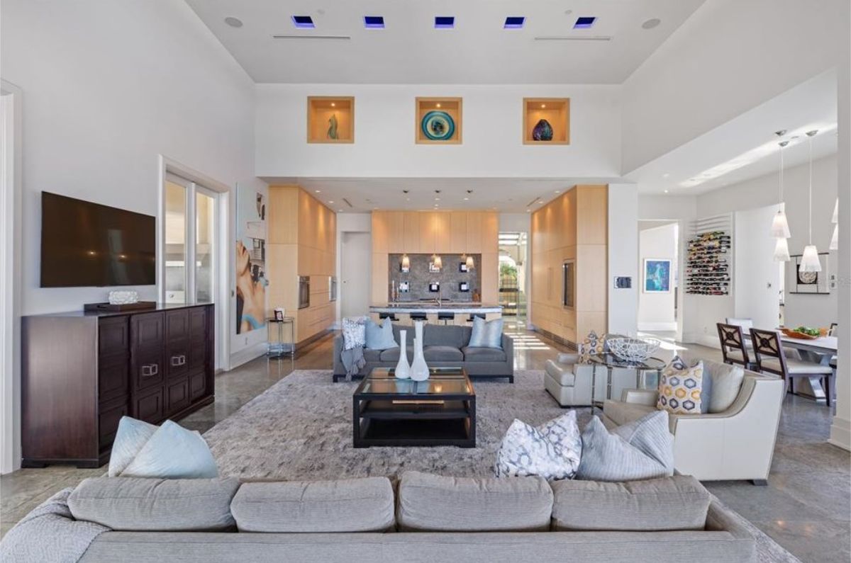 Cozy yet elegant living space with plush seating, decorative shelving, and recessed lighting. 