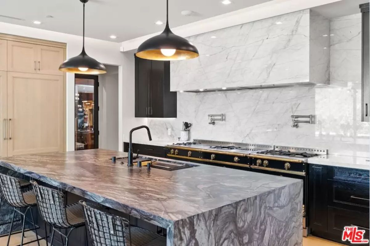 Contemporary kitchen combines black and wood cabinetry with a luxurious white marble finish. 