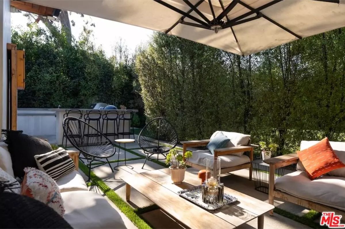 Inviting outdoor lounge area with comfortable seating under a large umbrella. 
