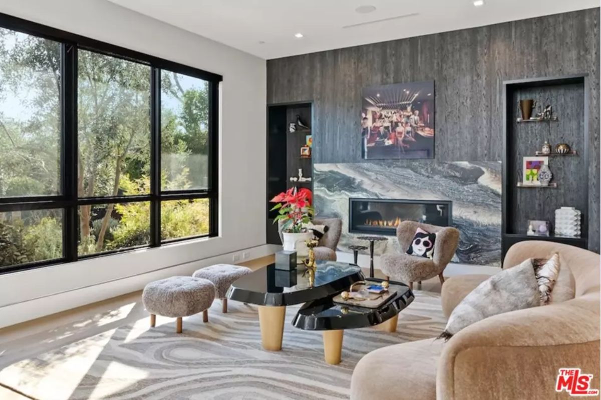 Cozy living room includes stylish furniture, a built-in fireplace, and large windows. 