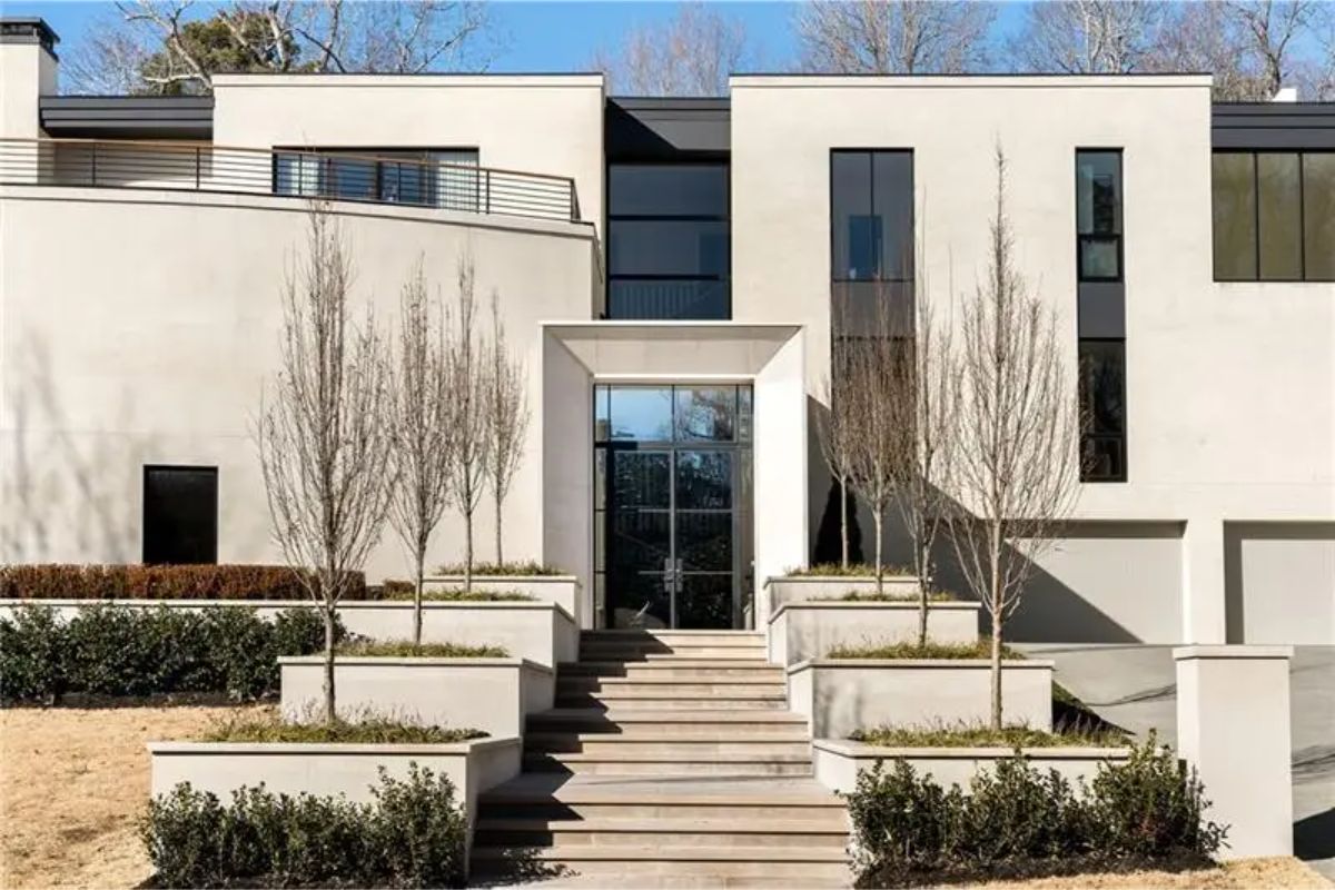 The symmetrical front entry is framed by minimalist landscaping and boxy planters. 