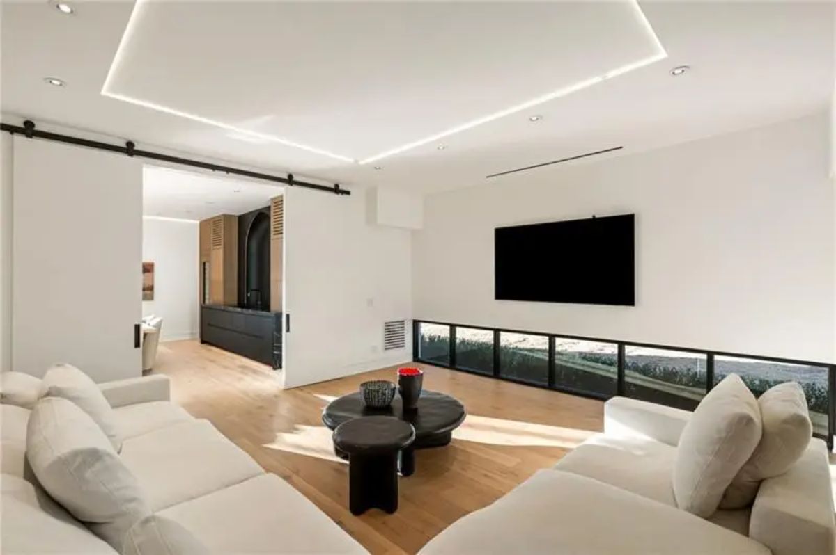 Entertainment room provides a comfy sectional, wall-mounted TV, and clean lines with a modern aesthetic. 