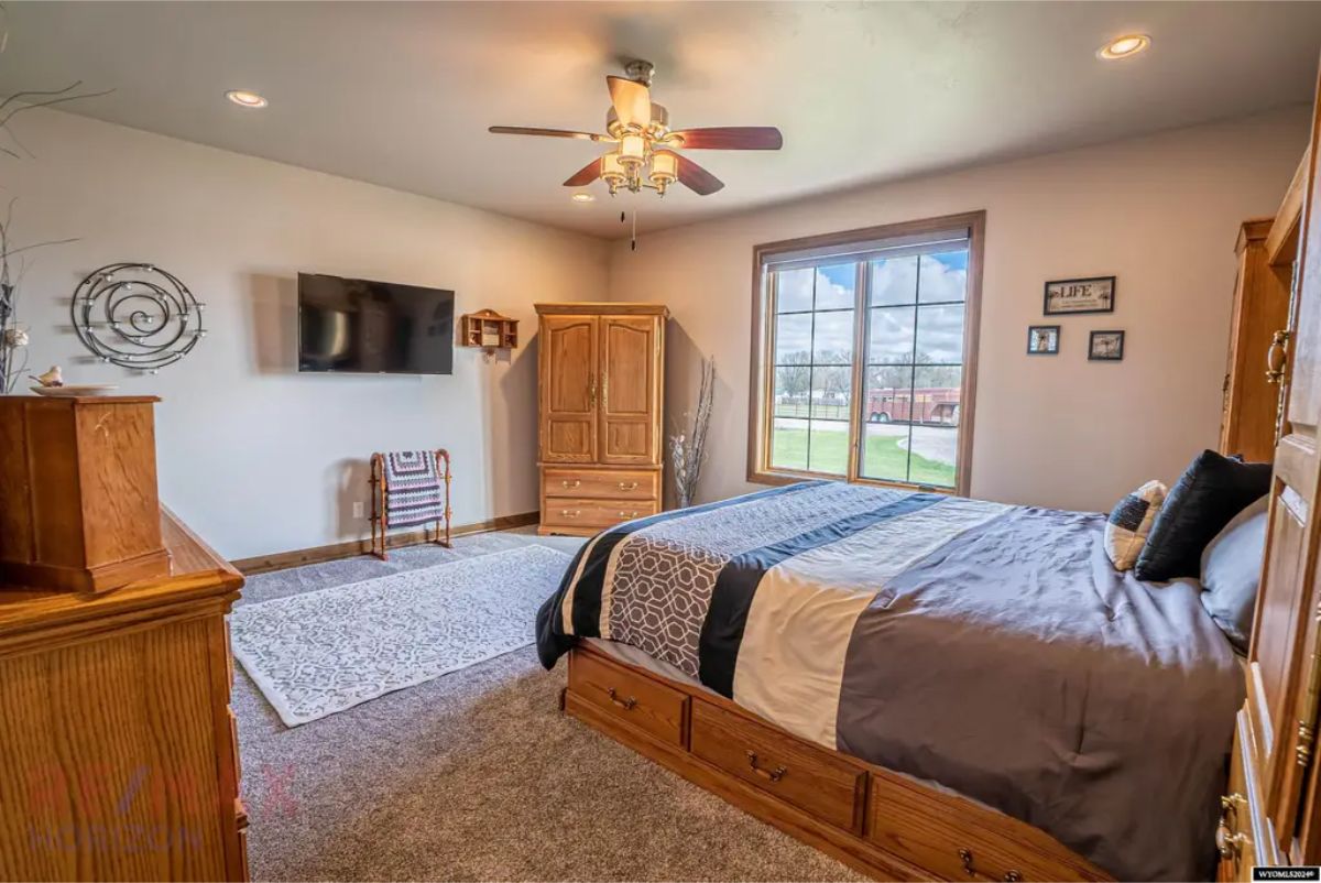 Wood-framed bed with built-in storage is placed against a neutral wall.