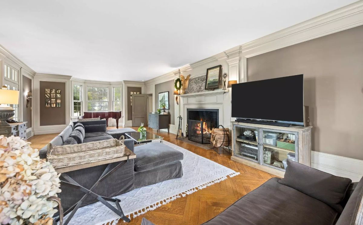 Gray walls and white trim surround a seating area focused on a central fireplace.