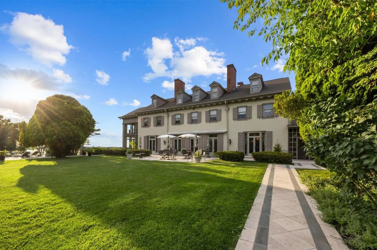 This elegant estate showcases classic Colonial Revival architecture with symmetrical windows, dormers,