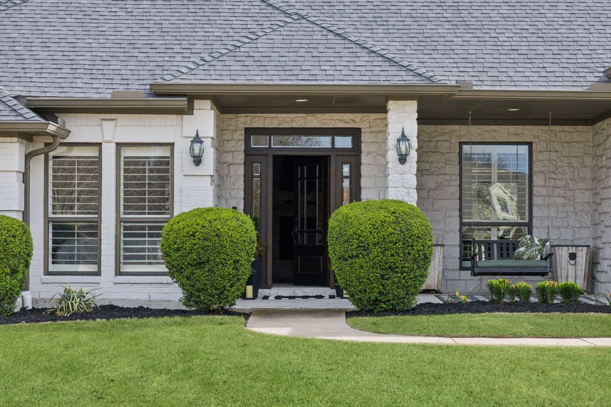 Stone facade is paired with dark trim and black front door.