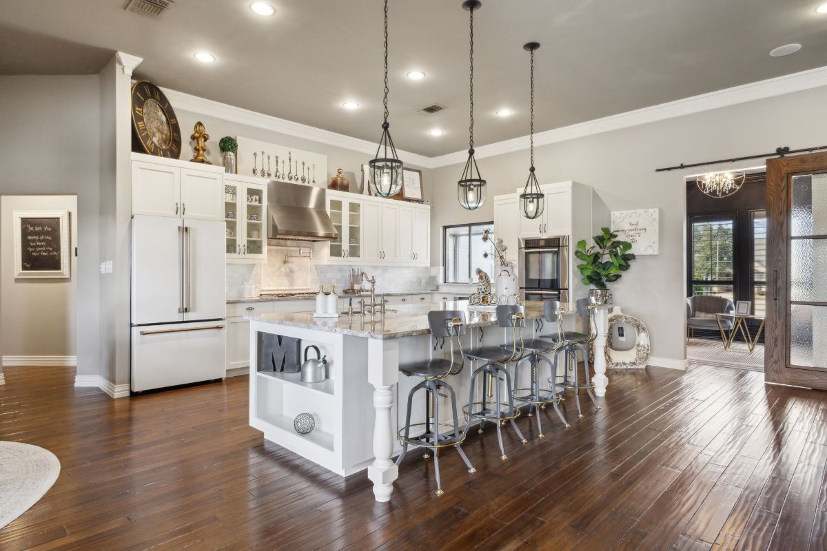 White cabinetry is topped with light stone countertops.